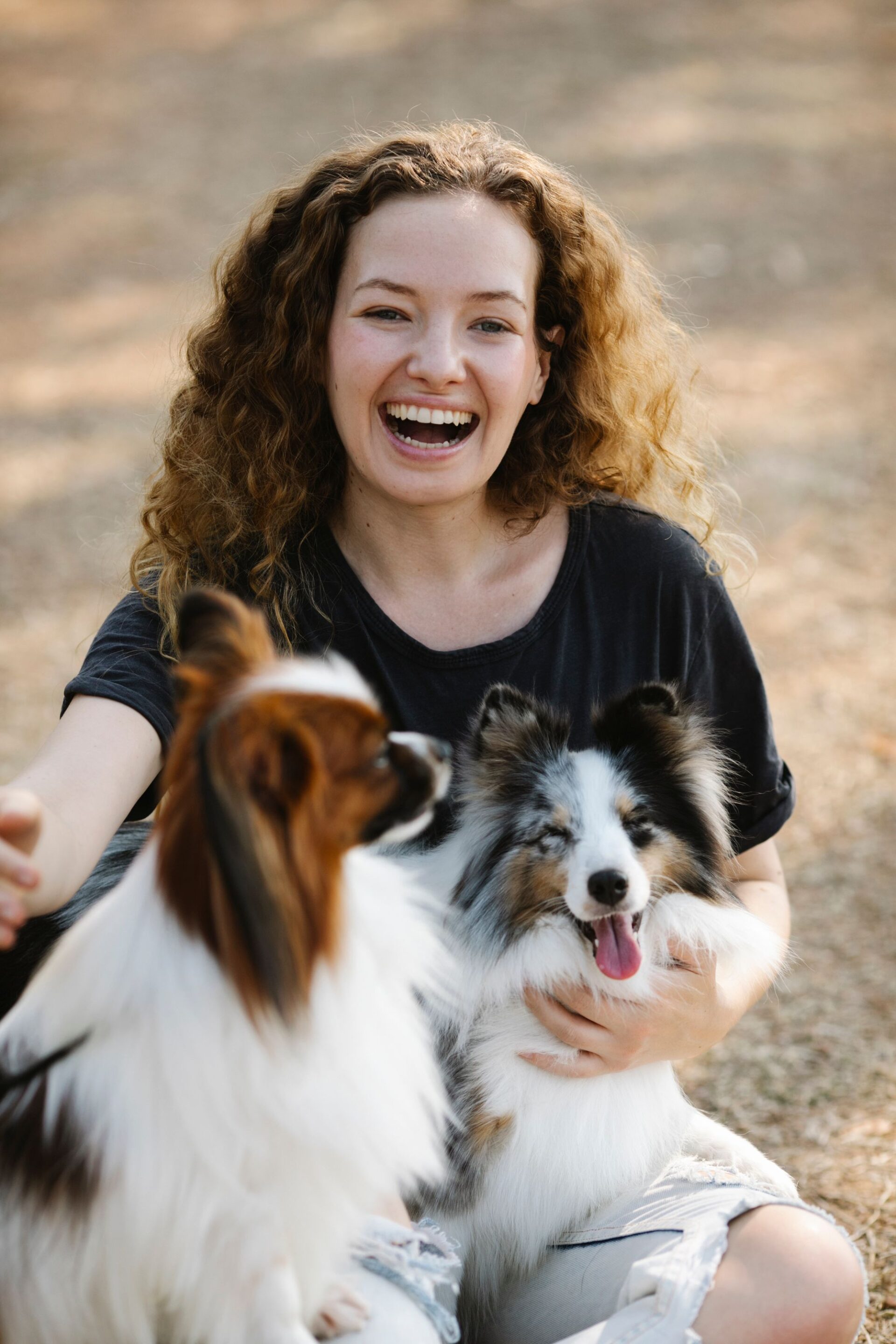 Woman hugging her two small dogs